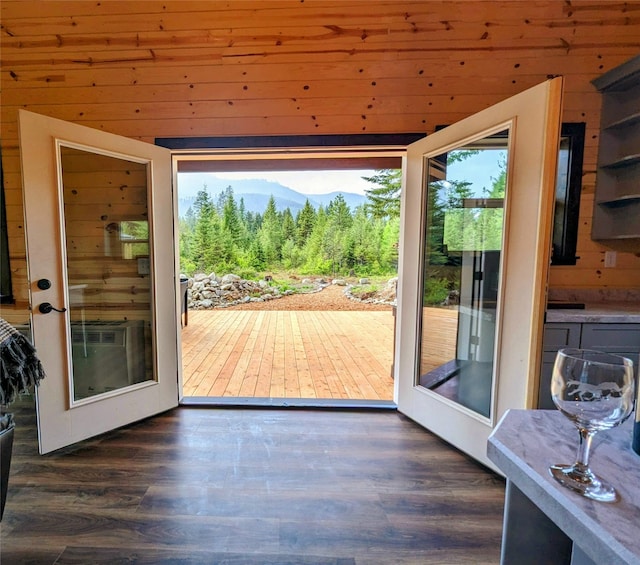 doorway to outside featuring dark wood-type flooring, wood walls, and french doors