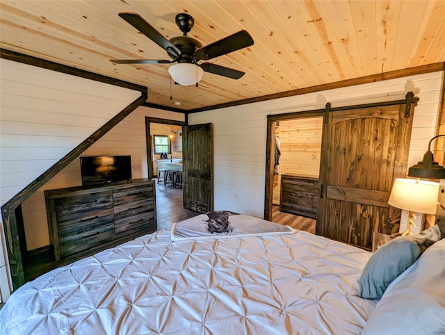 bedroom with wooden walls, ceiling fan, wooden ceiling, hardwood / wood-style flooring, and a barn door