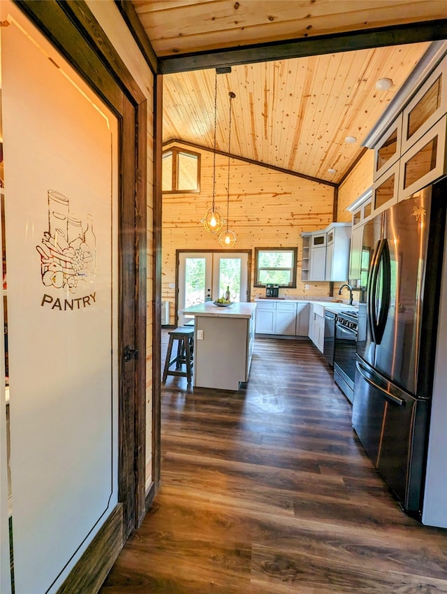 kitchen with pendant lighting, wood ceiling, stainless steel appliances, a kitchen island, and dark wood-type flooring