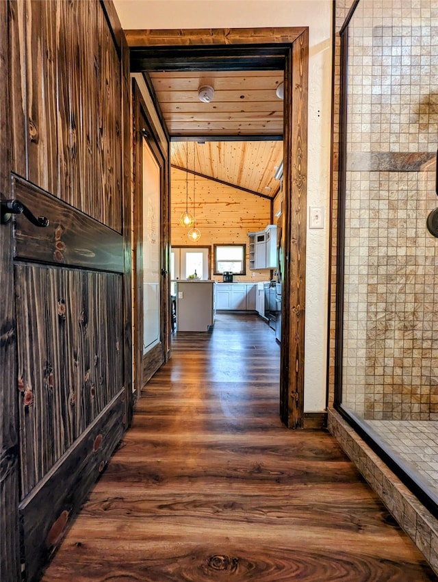 hallway featuring wooden ceiling, lofted ceiling, wood walls, and dark hardwood / wood-style floors