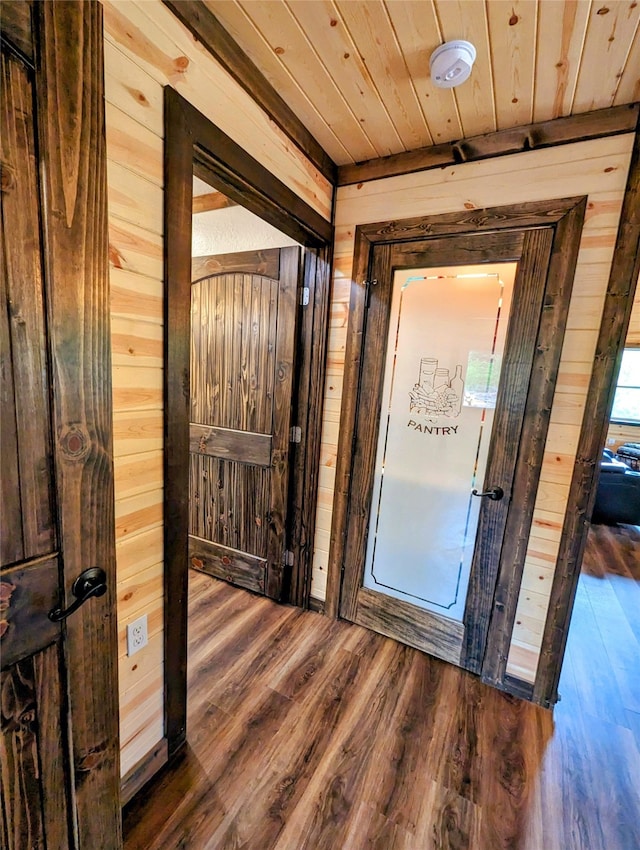 interior space with wood walls, wood-type flooring, and wood ceiling