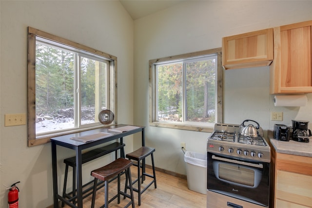 kitchen featuring light brown cabinets, gas stove, and light hardwood / wood-style floors