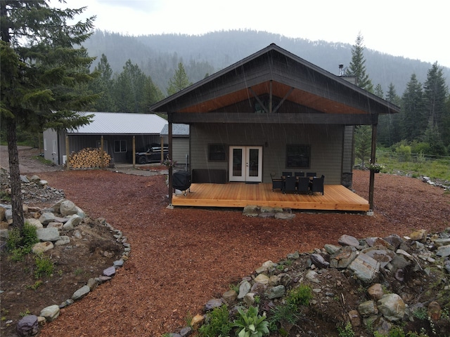 rear view of property featuring a deck with mountain view and french doors