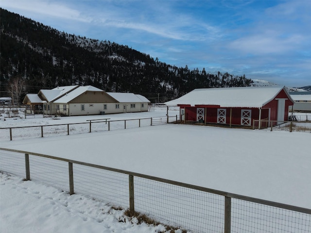 snowy yard featuring an outdoor structure and a mountain view