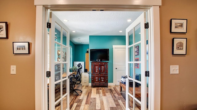 home office with french doors, wood-type flooring, and a textured ceiling