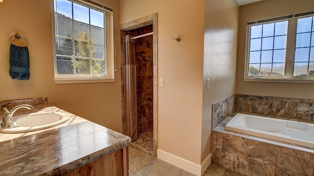 bathroom with vanity, separate shower and tub, and a wealth of natural light