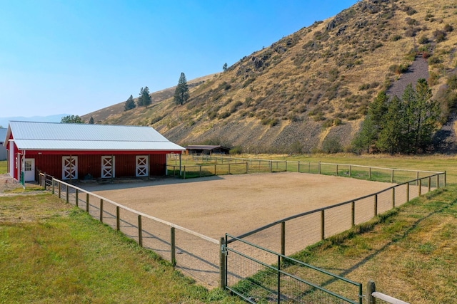 view of yard featuring a rural view, a mountain view, and an outdoor structure