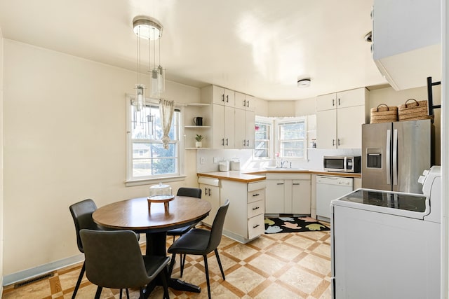 kitchen featuring white cabinetry, a healthy amount of sunlight, stainless steel appliances, and sink