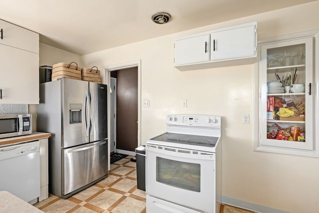 kitchen featuring stainless steel appliances and white cabinetry