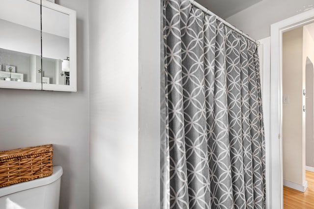 bathroom featuring a shower with shower curtain, toilet, and wood-type flooring