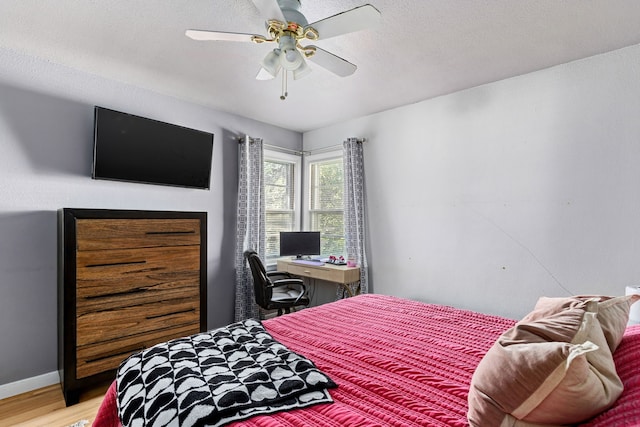 bedroom with a textured ceiling, light hardwood / wood-style flooring, and ceiling fan