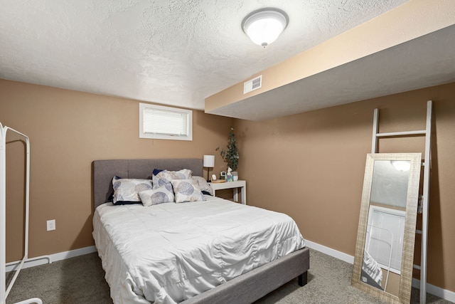 bedroom featuring carpet flooring and a textured ceiling