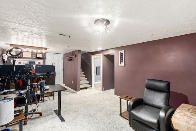 carpeted home office featuring a textured ceiling