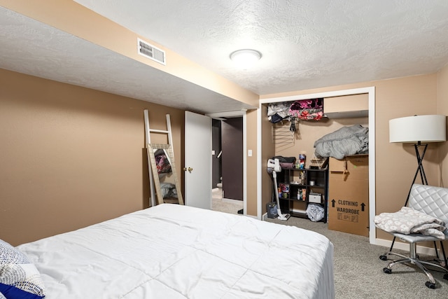 carpeted bedroom featuring a closet and a textured ceiling