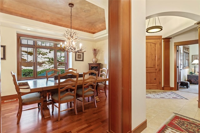 dining room with arched walkways, baseboards, and a chandelier
