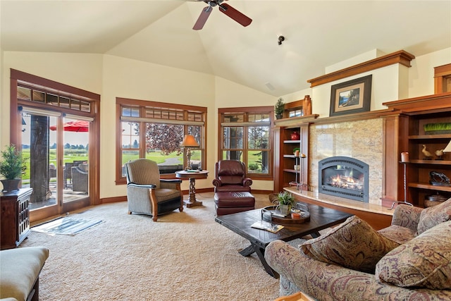 carpeted living room featuring ceiling fan, baseboards, high vaulted ceiling, and a fireplace