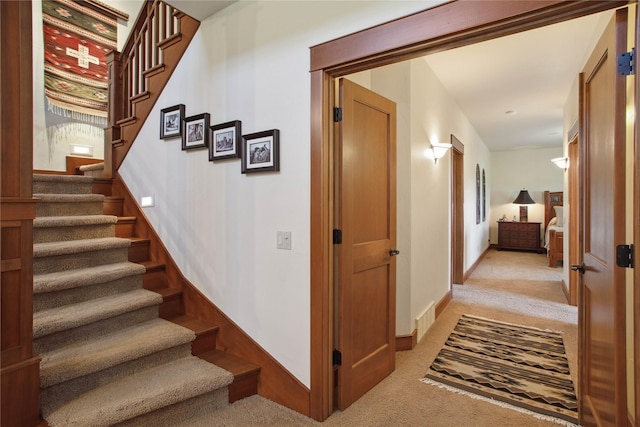 stairs with baseboards, visible vents, and carpet