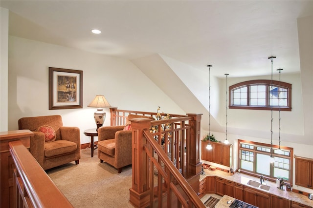 sitting room featuring recessed lighting, a towering ceiling, an upstairs landing, and light colored carpet