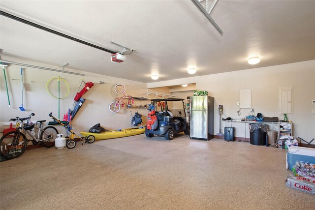 garage featuring freestanding refrigerator and a garage door opener