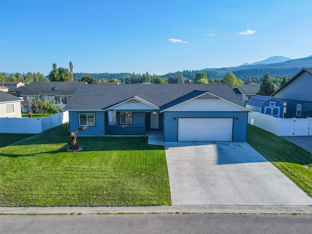 ranch-style house with a mountain view, a garage, and a front lawn