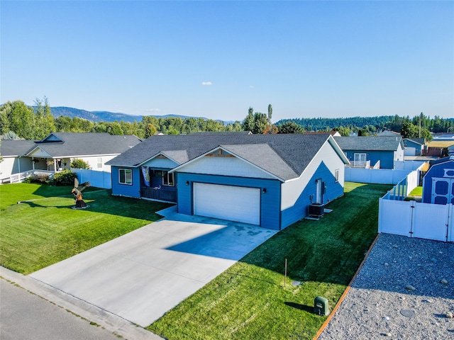 ranch-style home with a garage, a front lawn, and central AC