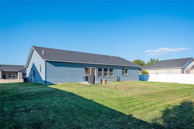 rear view of property featuring a yard and central AC