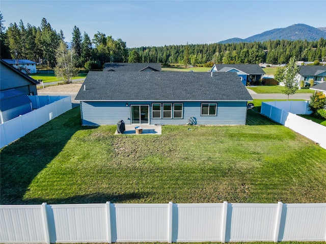 exterior space with a front lawn, a patio, and a mountain view