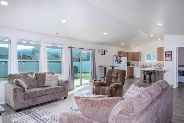 living room featuring plenty of natural light, vaulted ceiling, and light hardwood / wood-style floors