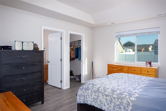 bedroom with hardwood / wood-style floors, a walk in closet, and a closet