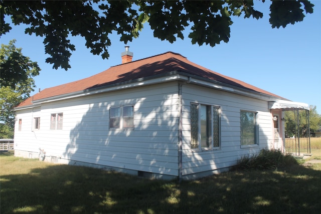 view of side of home with a yard