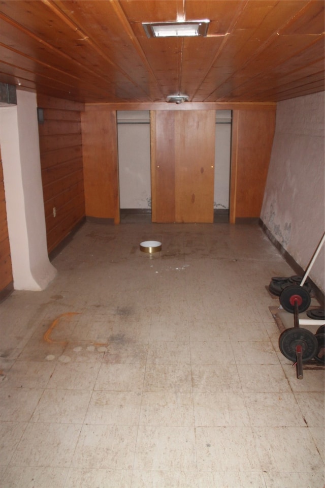 basement with wood ceiling and wood walls