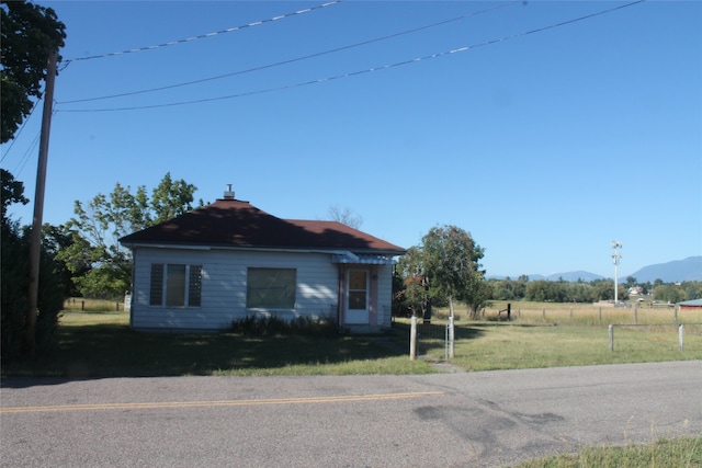 view of front of house featuring a mountain view and a front lawn