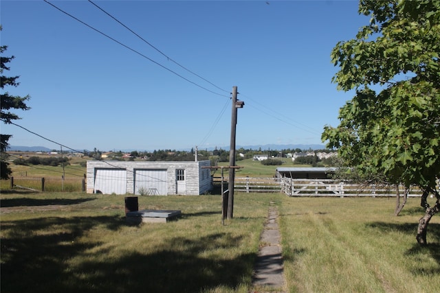 view of yard with a rural view and an outdoor structure