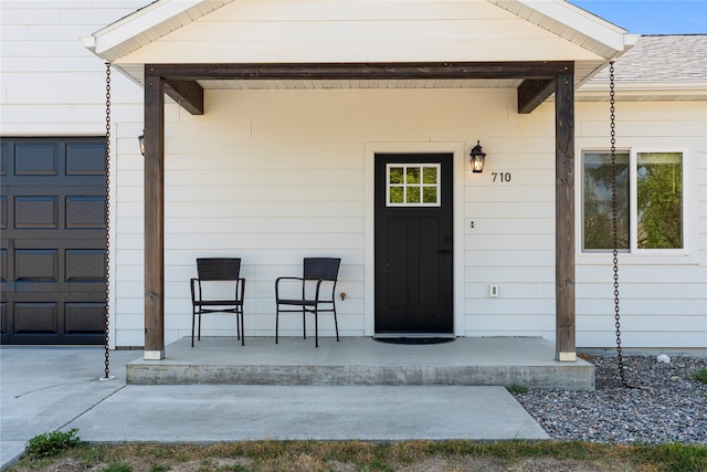 property entrance featuring covered porch and a garage