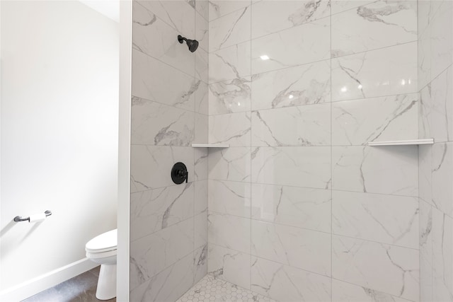 bathroom featuring toilet and a tile shower