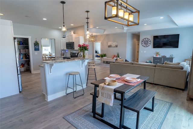 dining space with light hardwood / wood-style flooring and a chandelier