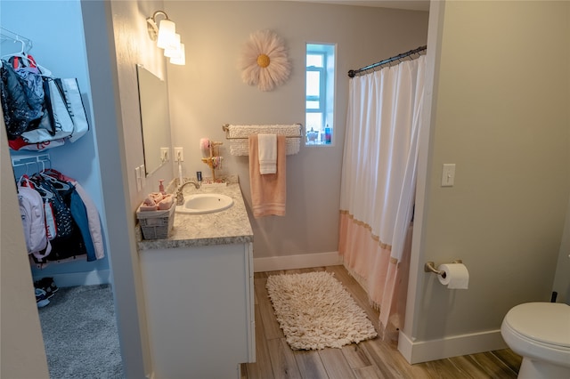 bathroom with vanity, toilet, hardwood / wood-style floors, and curtained shower