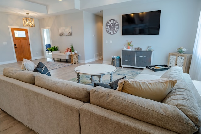 living room featuring a chandelier and light hardwood / wood-style floors