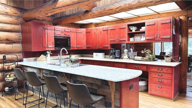 2100 Four Mile Way, Kalispell, MT 59901 - kitchen featuring black microwave, rustic walls, light wood finished floors, a peninsula, and dark brown cabinets