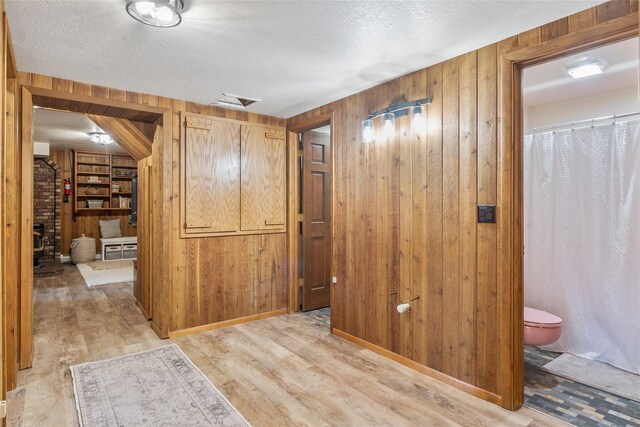 2100 Four Mile Way, Kalispell, MT 59901 - hall featuring wooden walls, light wood-type flooring, and a textured ceiling