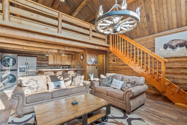 2100 Four Mile Way, Kalispell, MT 59901 - living room with estacked washer and dryer, high vaulted ceiling, a chandelier, stairs, and wood-type flooring