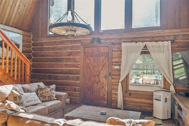 2100 Four Mile Way, Kalispell, MT 59901 - living area featuring rustic walls, stairs, wood finished floors, and high vaulted ceiling