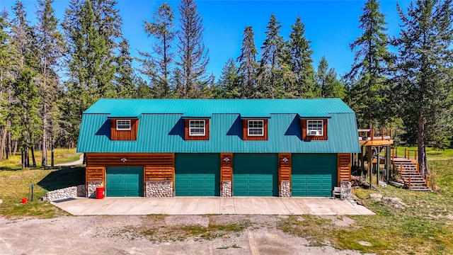 2100 Four Mile Way, Kalispell, MT 59901 - garage featuring dirt driveway, a detached garage, and view of wooded area