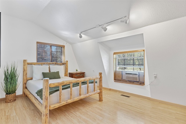 2100 Four Mile Way, Kalispell, MT 59901 - bedroom with track lighting, lofted ceiling, and wood finished floors
