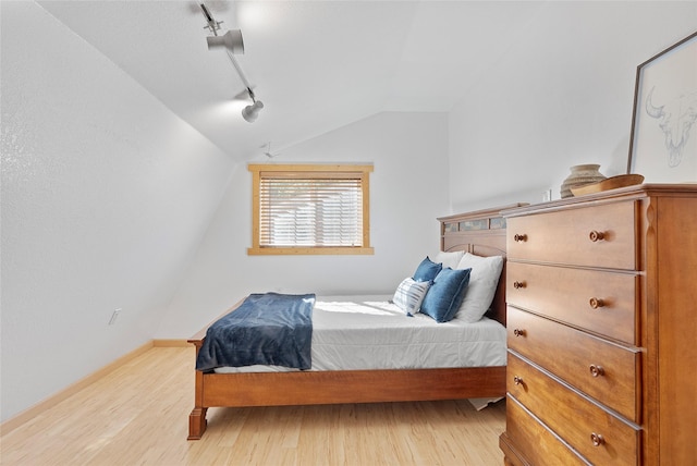 2100 Four Mile Way, Kalispell, MT 59901 - bedroom with vaulted ceiling, wood finished floors, and rail lighting