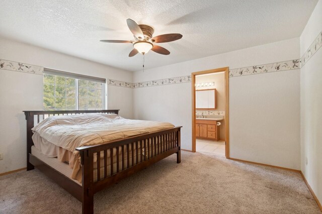 carpeted bedroom with ceiling fan, connected bathroom, and a textured ceiling