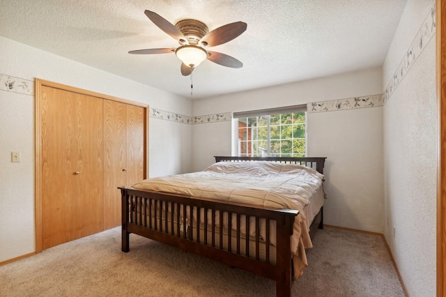 carpeted bedroom featuring a closet, a textured ceiling, a ceiling fan, and a textured wall