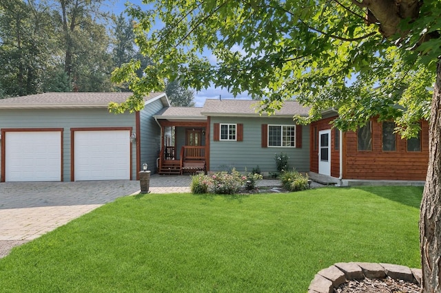 ranch-style house featuring a front lawn, decorative driveway, and a garage