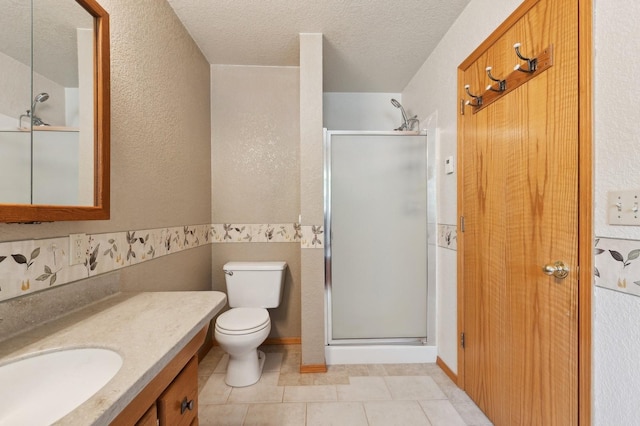 full bathroom with a shower stall, a textured ceiling, vanity, and toilet