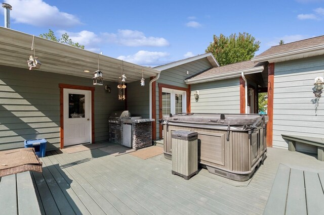 wooden terrace with a hot tub, an outdoor kitchen, and grilling area